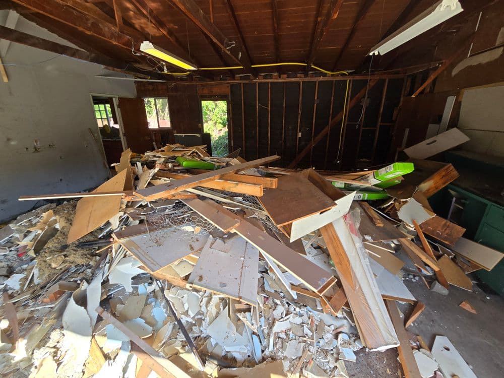 Interior of a demolished room filled with debris and rubble from construction.
