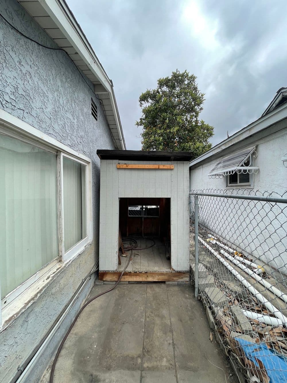 Renovation photo showing an open doorway of a home extension with cloudy skies above.