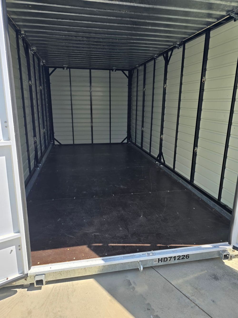 Empty storage container interior with metal walls and a flat floor. Ideal for storage solutions.