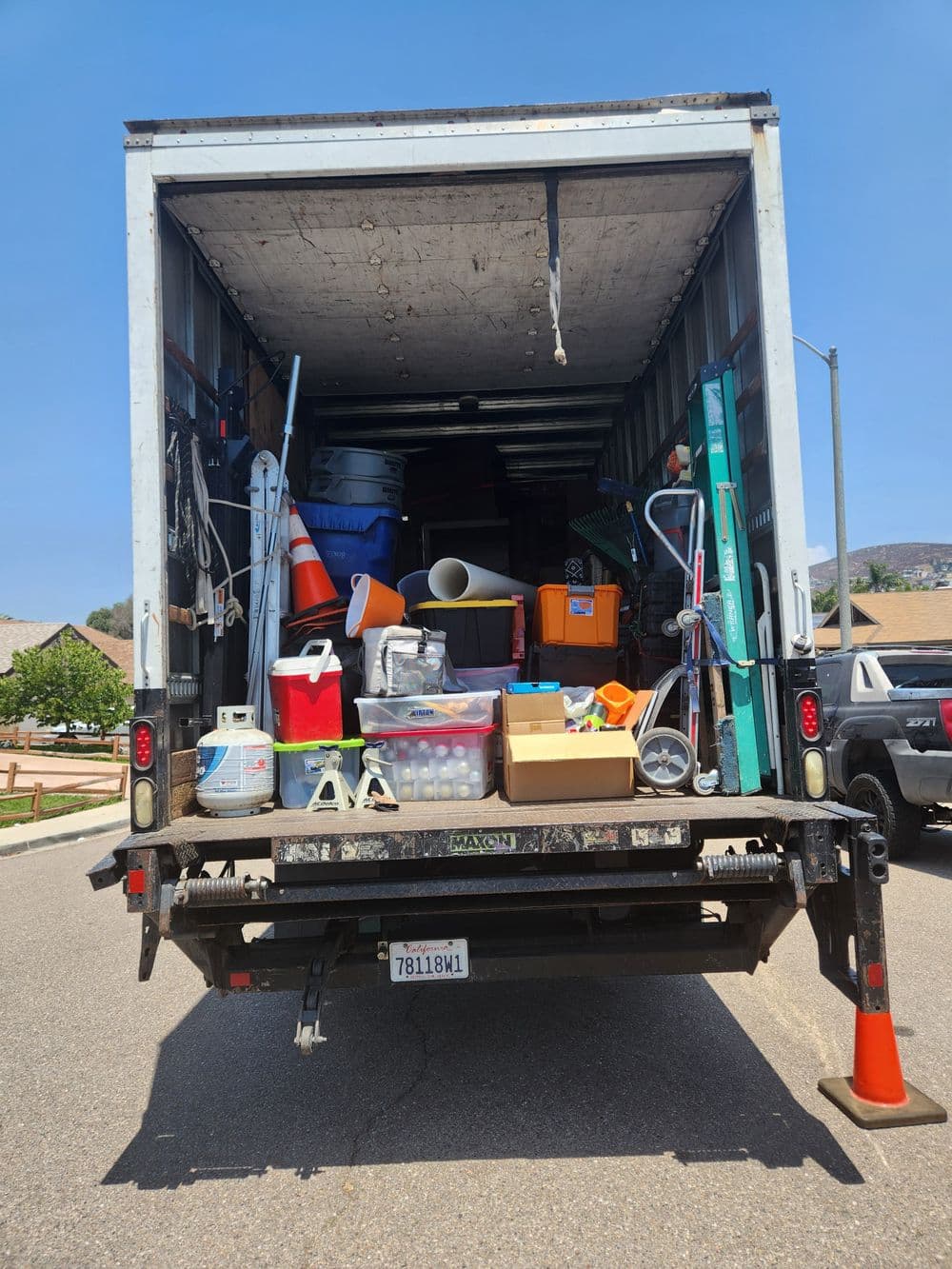 Tools and equipment loaded in a moving truck, ready for transport. Bright sunny day.